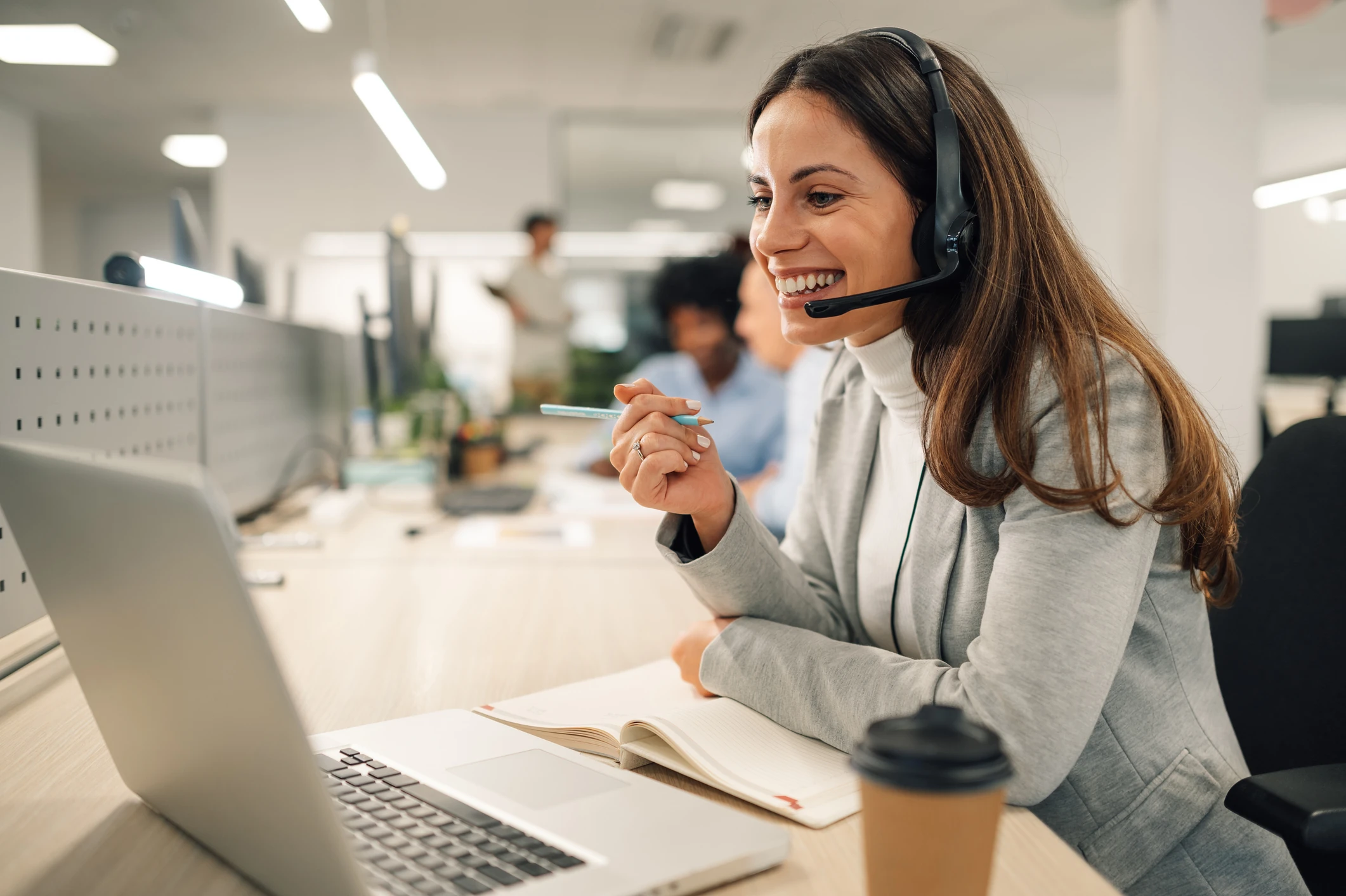 Support agent with a headset at her desk