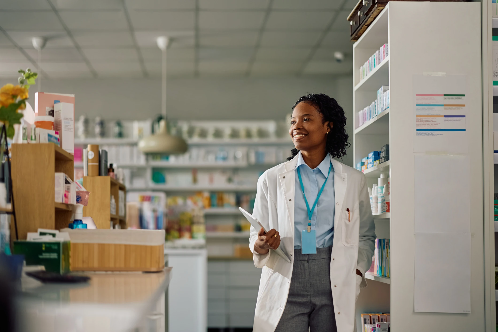 Pharmacist smiling in a pharmacy aisle