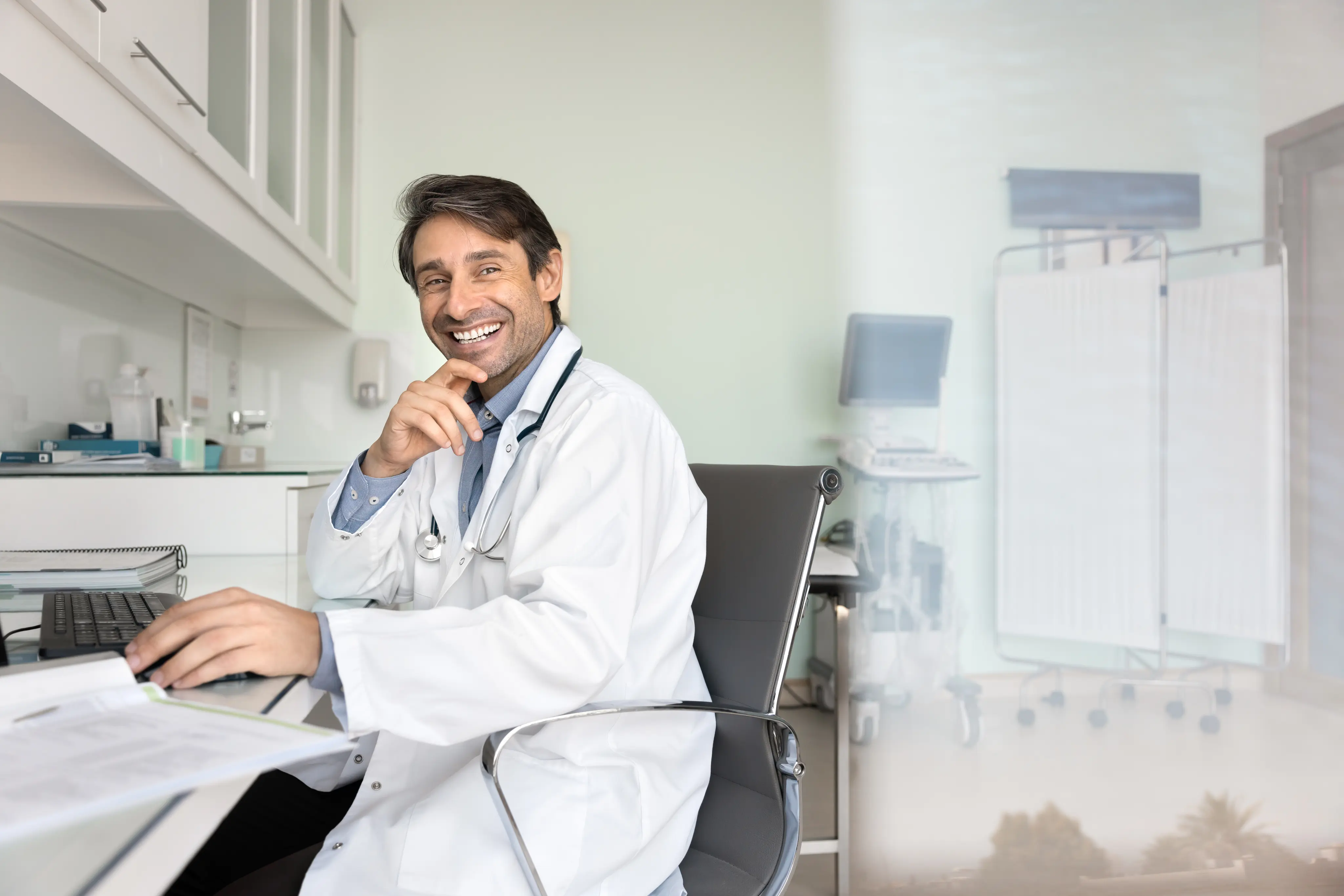 Doctor smiling at a laptop