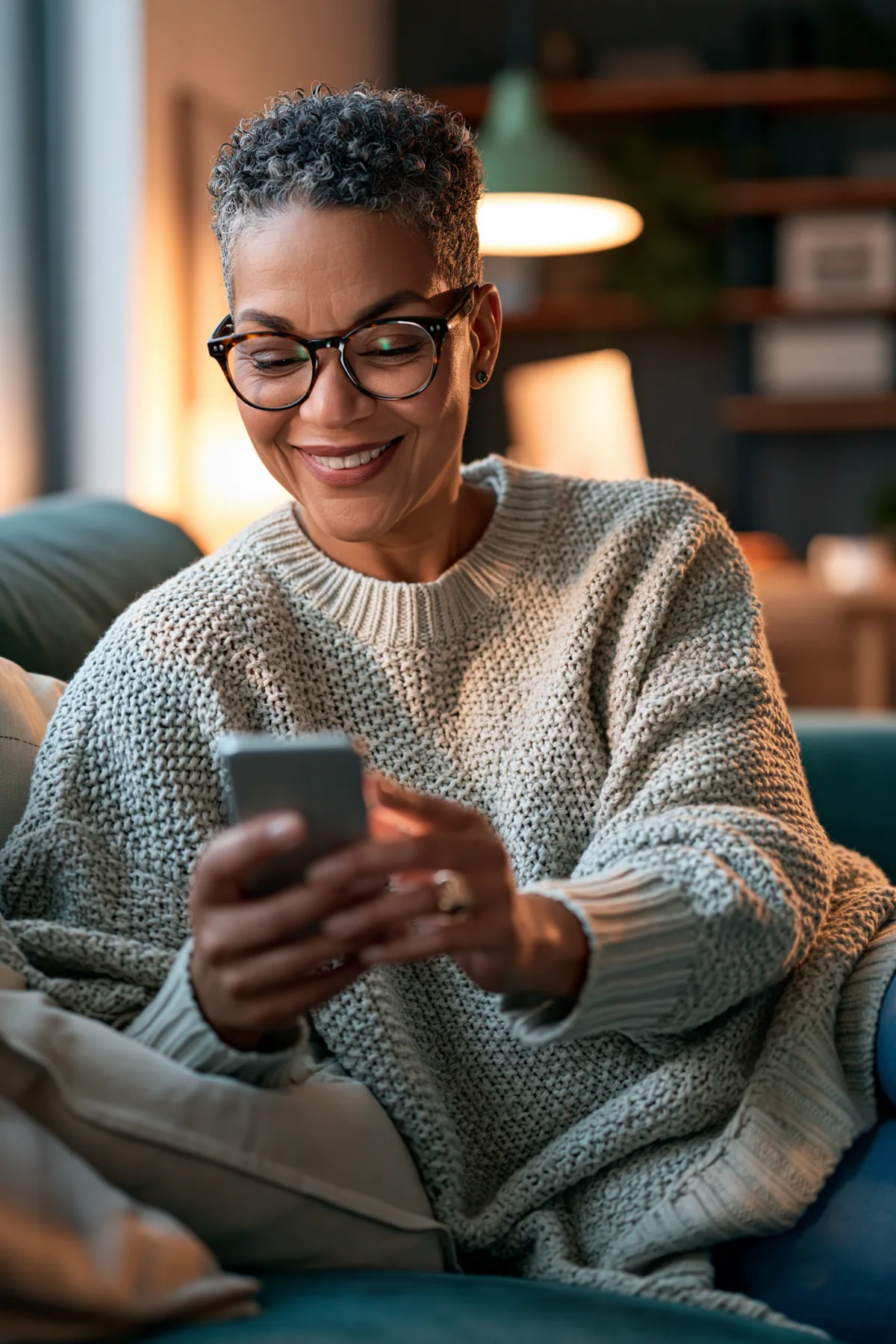 A smiling woman at home, looking at her phone