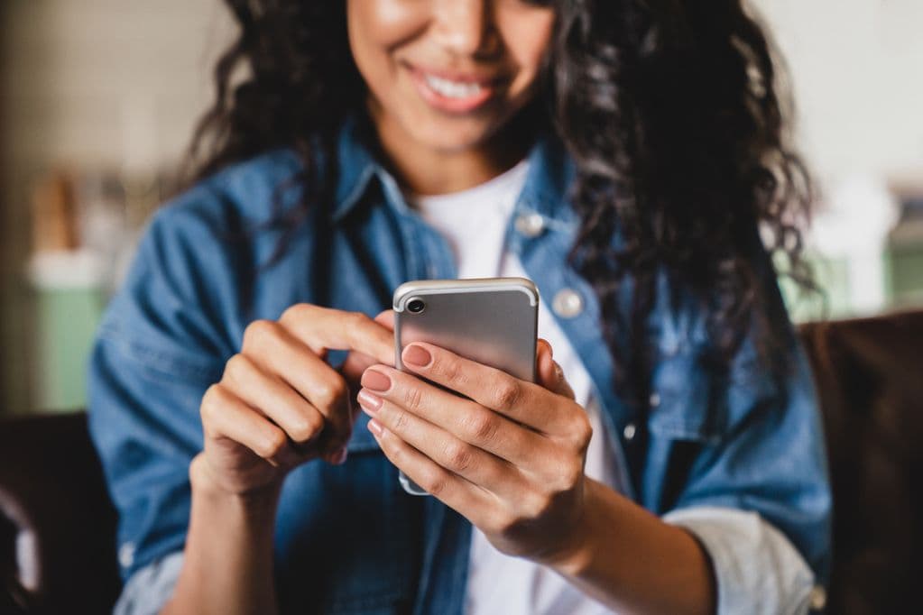 A woman smiling at her phone