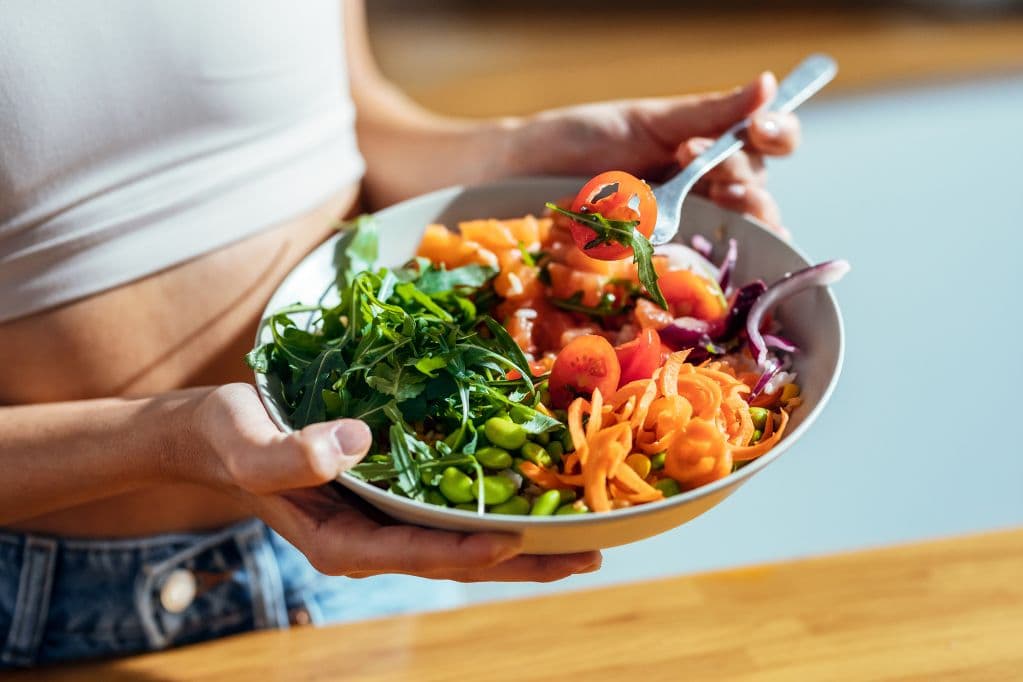 A woman holding a bowl of salad